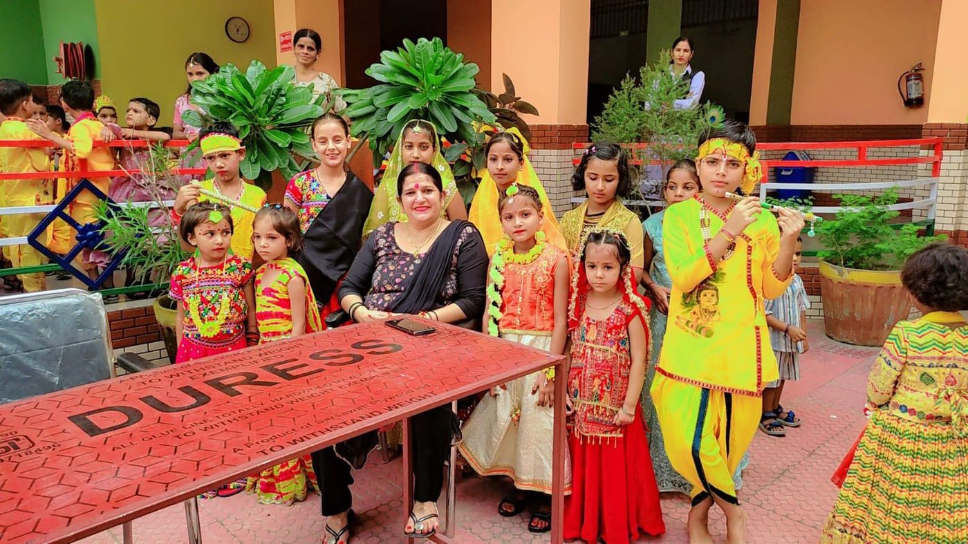 Students in Janmashtami costumes with a teacher