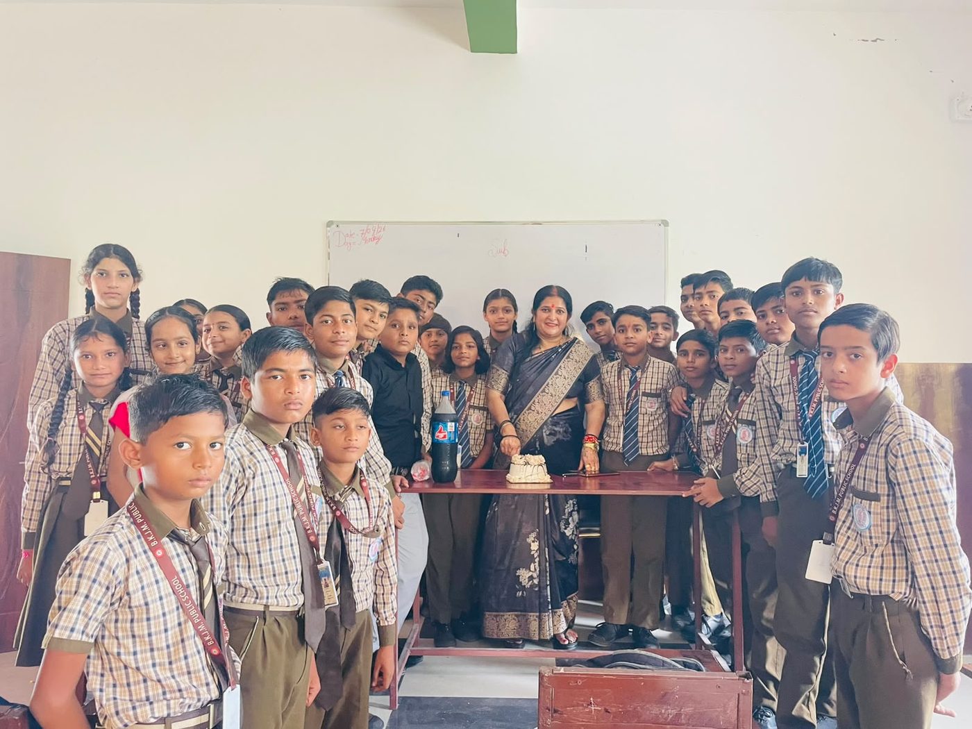 Principal cutting a cake with students