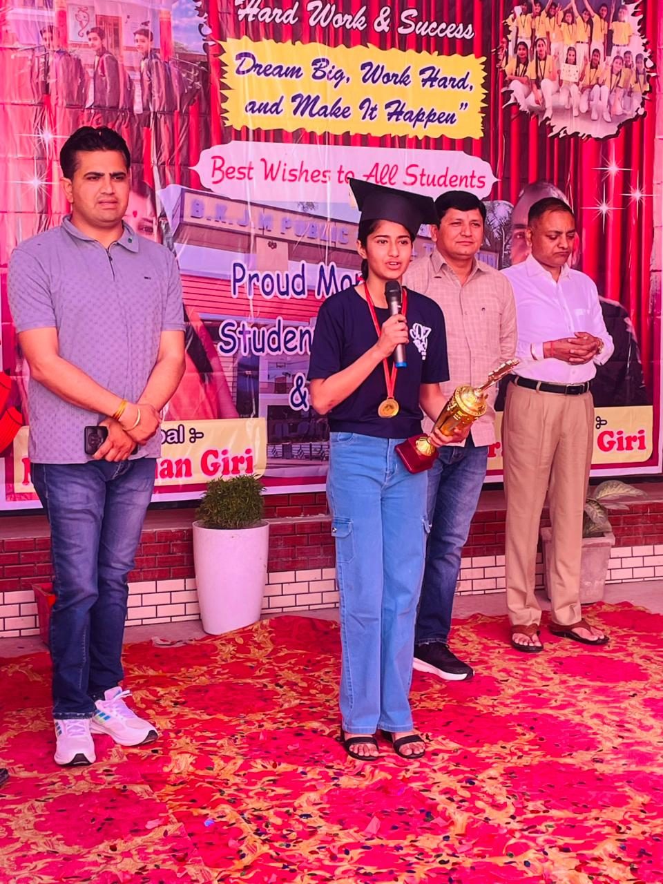 A student topper receiving her award on stage