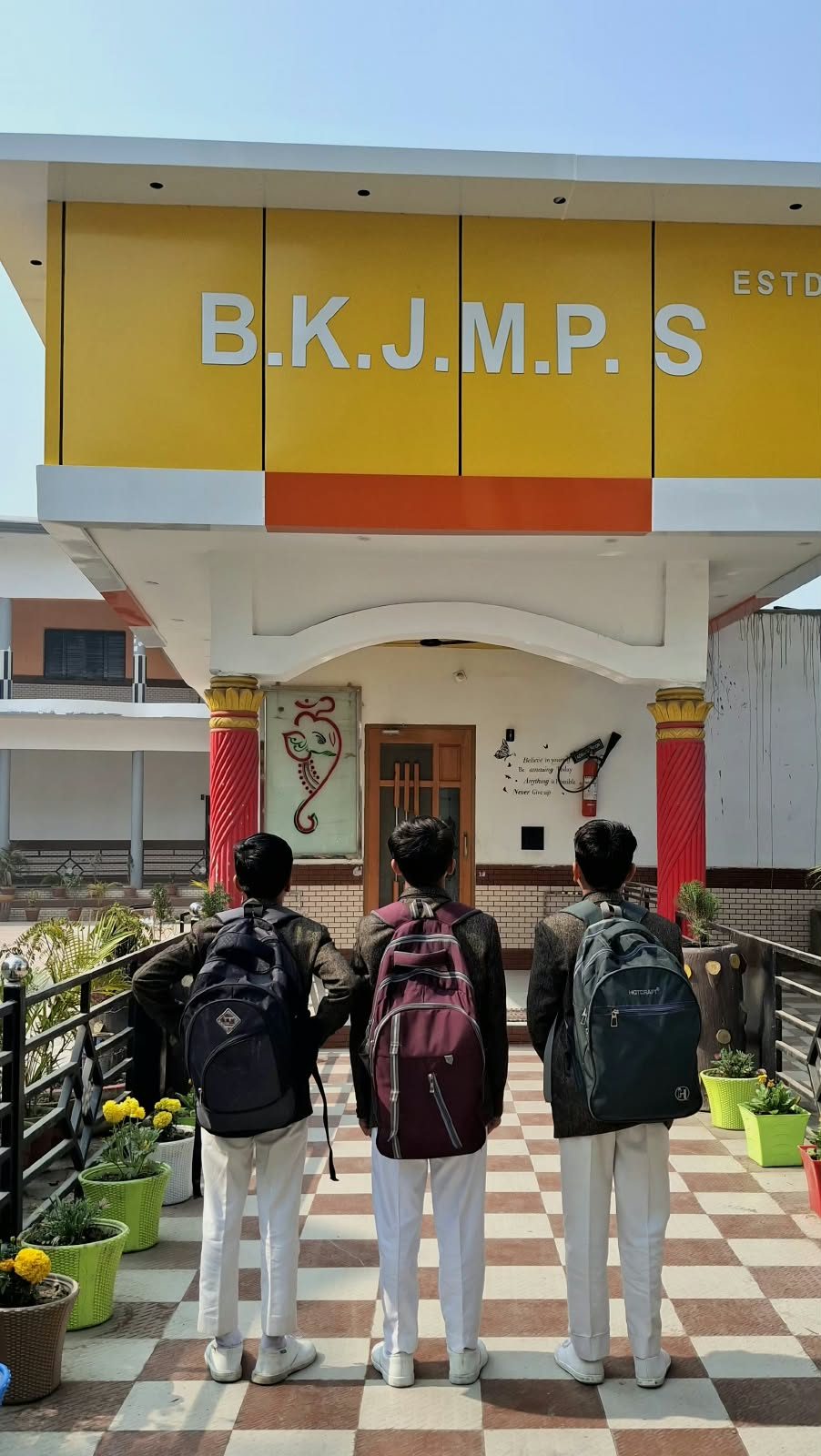 Students looking up at the school building sign